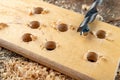 Drilling with a vane drill in chipboard. Carpentry work in a carpentry workshop Royalty Free Stock Photo