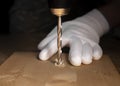 Drilling working process closeup. Modern steel drill tool making hole in wood and hands in builder gloves