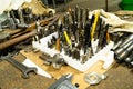 Drills, milling cutters and other metalworking tools on the table in the workshop.