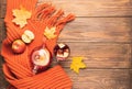 Drink autumn apple red berries in a glass teapot and an orange scarf on a wooden background. Hot fruit berry tea.