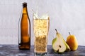 Drink bottle and glass. Carbonated water in a glass. Splashes from a glass. Pears and apples near the glass