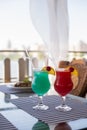 Drink cocktail alcohol turquoise blue hawaii and sex on the beach with cherry decoration in a restaurant Royalty Free Stock Photo