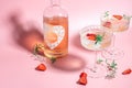 drink cocktail with ice in a glass on pink background. refreshing fruit cocktail or punch with wine champagne, strawberries, ice