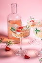 drink cocktail with ice in a glass on pink background. refreshing fruit cocktail or punch with wine champagne, strawberries, ice