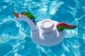 Drink cup in inflatable unicorn toy in swimming pool Royalty Free Stock Photo