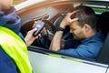 sad drunk man sitting in the car after police alcohol test with alcometer