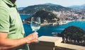 Drink glass white wine in male hands holidays looks top view city coast yacht from observation deck, romantic tourist man toast Royalty Free Stock Photo