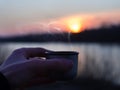 Drink hot tea from a thermos against the background of the sunset in the first days of spring Royalty Free Stock Photo