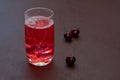 Drink with iced cherries, sweet cherries on a dark background. Fresh plum cocktail. Fresh summer cocktail with cherries and ice Royalty Free Stock Photo
