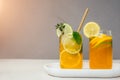 Drink with orange lemon and lime in glass transparent glasses on a concrete background. Lemonade with ice Royalty Free Stock Photo