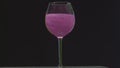 Drink shimmers in a glass on isolated background. Stock footage. Beautiful alcoholic drink with sequins in transparent