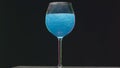 Drink shimmers in a glass on isolated background. Stock footage. Beautiful alcoholic drink with sequins in transparent