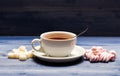 Drink and sweets prepared as dessert. Tea break concept. Mug filled with black brewed tea, spoon and heap of marshmallow Royalty Free Stock Photo