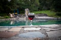 Drink in tall glass in poolside. Refreshment on summer day. Purple juice cocktail or vine. Mountain forest background. Royalty Free Stock Photo