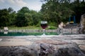 Drink in tall glass in poolside. Refreshment on summer day. Purple juice cocktail or vine. Mountain forest background. Royalty Free Stock Photo