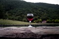 Drink in tall glass in poolside. Refreshment on summer day. Purple juice cocktail or vine. Mountain forest background. Royalty Free Stock Photo