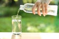Drink water pouring into empty glass with natural green background Royalty Free Stock Photo