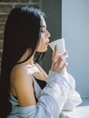 Drinking alone. Pretty woman drinking fresh hot coffee at window. Sensual girl drinking her favorite morning beverage Royalty Free Stock Photo