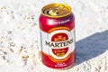 Drinking a can of cold beer Martens on beach paradise