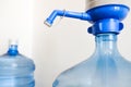 Drinking clean water at home. Close up tap view of large blue pump cooler bottle mechanism for house or office use. Two bottles Royalty Free Stock Photo