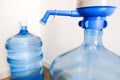 Drinking clean water at home. Close up tap view of large blue pump cooler bottle mechanism for house or office use. Two bottles Royalty Free Stock Photo