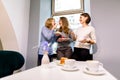 Drinking coffee and eating desserts together. Three beautiful women holding plates with delicious cakes desserts in cafe Royalty Free Stock Photo