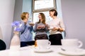 Drinking coffee and eating desserts together. Three beautiful women holding plates with delicious cakes desserts in cafe Royalty Free Stock Photo