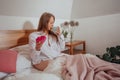 Drinking coffee and eating doughnut for breakfast in bed