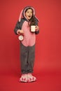 Drinking coffee energy. Morning routines. Adorable bunny hold alarm clock. Small girl in bunny costume. Child rabbit Royalty Free Stock Photo