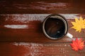 Drinking Coffee in Fall and Autumn Season. Hot Coffee Cup on Orange Brown Wooden Table. Top View. Focus on Cup