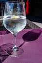 Drinking cold mineral water with bubbles, served in wine glass with ice cubes and lemon Royalty Free Stock Photo