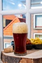 Drinking dark beer with fried cod fish fillet and french fried potatoed chips with view on street in old Zierikzee town, Zeeland,