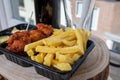 Drinking dark beer with fried cod fish fillet and french fried potatoed chips with view on street in old Zierikzee town, Zeeland,