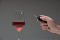 Drinking and driving concept shot. Male hand holding car keys next to tall wine glass, studio shot Royalty Free Stock Photo