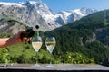 Drinking of dry white Roussette de Savoie and Vin de Savoie wine from Savoy region with view on Hautes Alpes mountains with snow