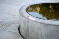 Drinking fountain, circular fountain and water drain into a concrete channel with a perforated lid. handmade atypical cast in the Royalty Free Stock Photo