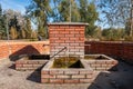 Drinking fountain faucet made of red bricks with fresh cold water running out from the ground of the earth Royalty Free Stock Photo