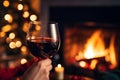 Drinking a glass of red wine in front of fireplace. Relaxing by the fire in cozy living room on winter day. Celebrating Christmas Royalty Free Stock Photo