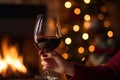 Drinking a glass of red wine in front of fireplace. Relaxing by the fire in cozy living room on winter day. Celebrating Christmas Royalty Free Stock Photo