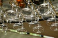 Drinking glasses hanging from a rack in a bar or restaurant.