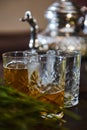 Drinking glasses with traditional North African tea and silver teapot on blurred background. Moroccan mint tea. Close-up Royalty Free Stock Photo