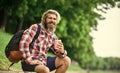 Drinking hot coffee. Drink tea or coffee. Man with cup outdoors. Enjoying nature at riverside. Guy with backpack Royalty Free Stock Photo