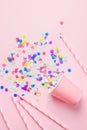 Drinking Paper Cup Striped Straws Colorful Confetti Scattered on Fuchsia Background. Flat Lay Composition. Birthday Party Kids