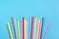 Drinking straws with stripes for party in glass on blue background. Royalty Free Stock Photo