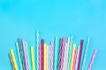 Drinking straws with stripes for party in glass on blue background. Royalty Free Stock Photo