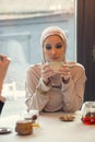 Beautiful arab woman meeting at cafe or restaurant with friend, spending time with cup of tea Royalty Free Stock Photo