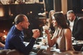 Drinking tea and looking at each other. Beautiful couple. Family friends having nice time in beautiful luxury modern Royalty Free Stock Photo