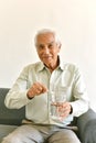 Drinking water is good healthy habit for old man, Elderly smiling asian man pointing at glass of purified water.