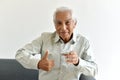 Drinking water is good healthy habit for old man, Elderly smiling asian man show thumb up to glass of purified water.