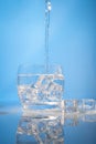 drinking water with ice on blue background Royalty Free Stock Photo